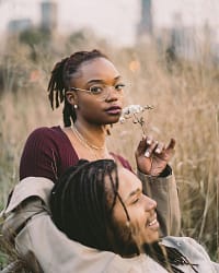 A couple enjoying a serene moment in a grassy field, showcasing love and togetherness.